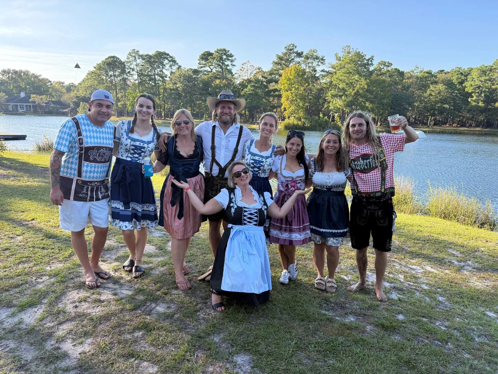 Amigos con dirndl y lederhosen celebrando Oktoberfest junto al lago en Charleston Aqua Park, Johns Island