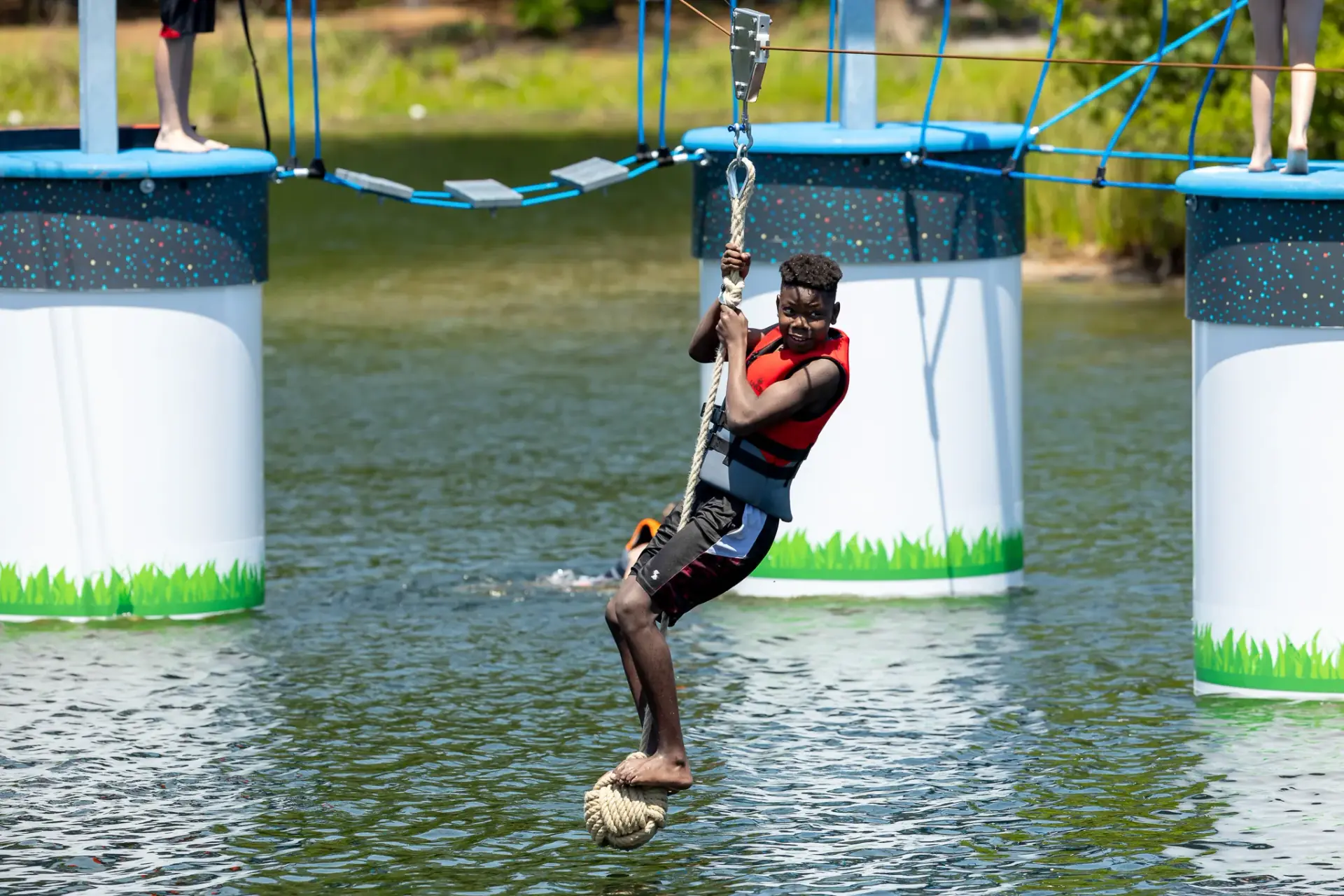 Summer camp kids on floating ropes course with zipline